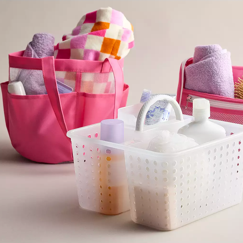 Various bath items including towels, a sponge, body wash, lotion, and other toiletries in organizer caddies.