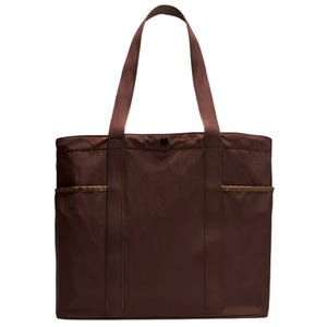 A brown tote bag with a simple design featuring two long handles and exterior side pockets.