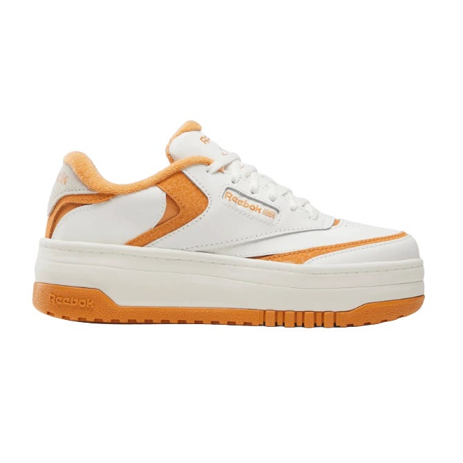 Reebok Club C Extra shoes with a white and orange design, featuring a platform sole and suede accents on a leather upper.