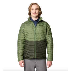 A man is wearing a light green Columbia insulated jacket with darker green accents, over a dark blue shirt.