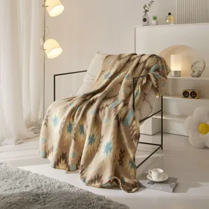 A beige patterned blanket draped over a bed frame in a stylish room with modern decor and furniture.