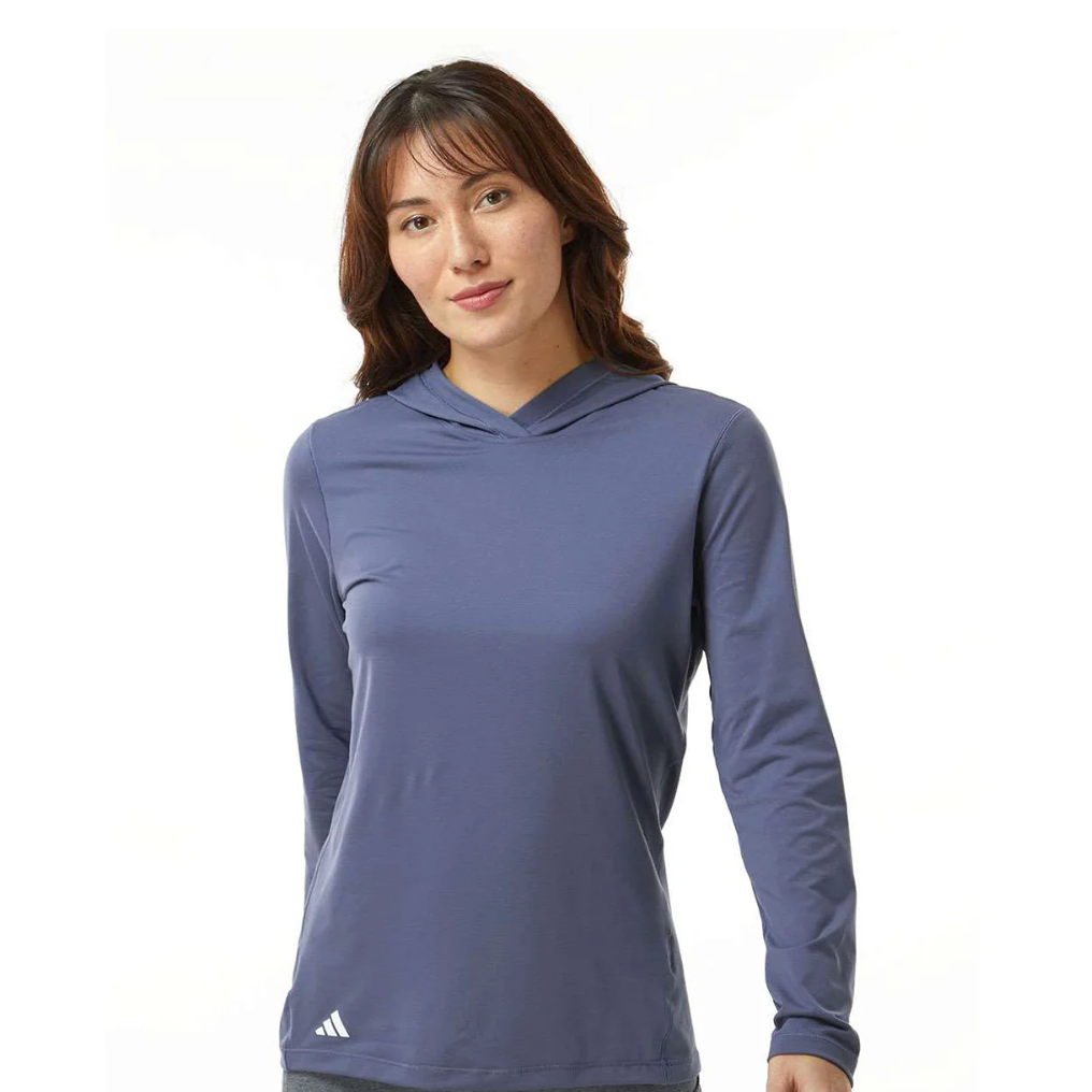 A person wearing a long-sleeve, blue hooded shirt with a small white logo near the hem.