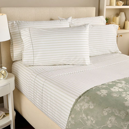 Striped bed sheet set with matching pillowcases on a neatly made bed.