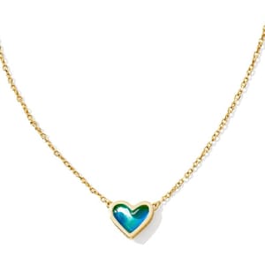 Gold chain necklace with a heart-shaped, iridescent blue-green charm set in gold.