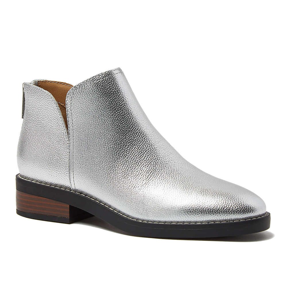Silver metallic ankle boot with a low stacked heel, featuring a textured finish and side cut-out detail.