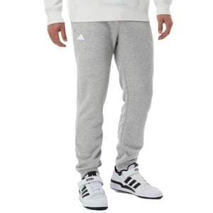 Grey sweatpants paired with white and black Adidas sneakers.