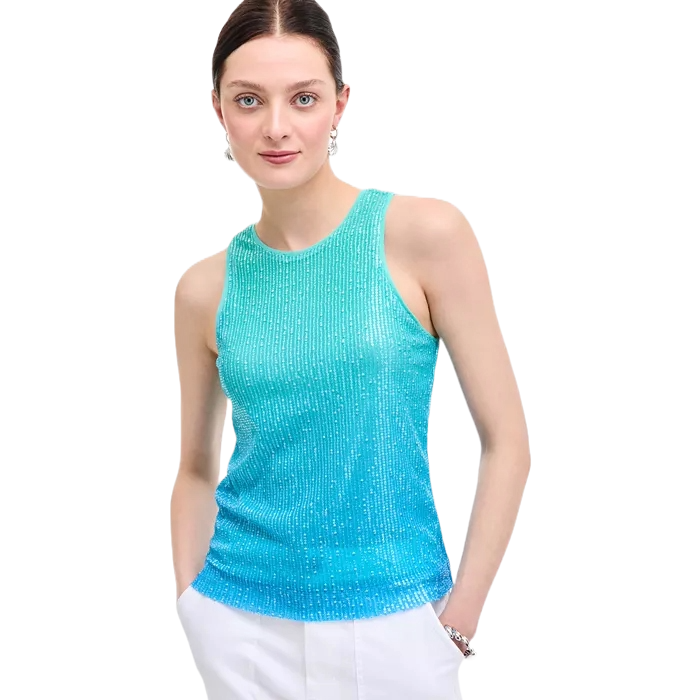A model is wearing a sleeveless, shimmering aqua blue top with a ribbed texture, paired with white pants.