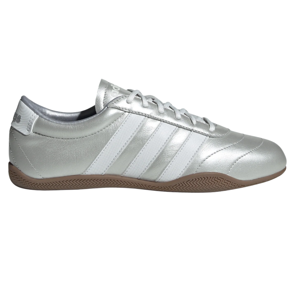 A silver Adidas Samba sneaker featuring white stripes and a gum sole.