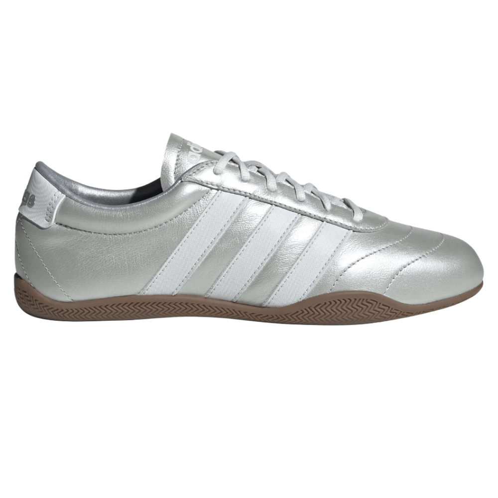 A silver Adidas Samba sneaker featuring white stripes and a gum sole.