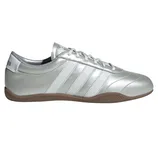A silver Adidas Samba sneaker featuring white stripes and a gum sole.