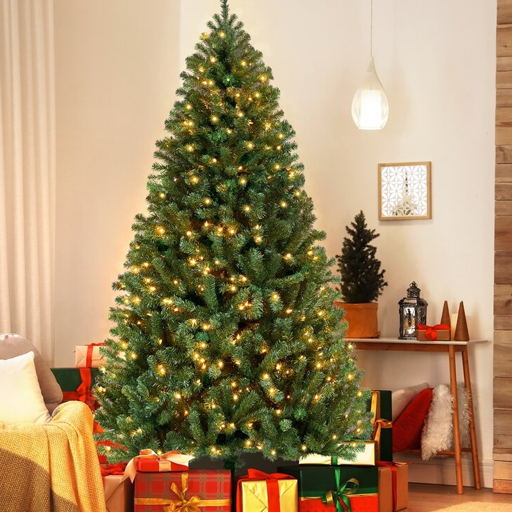 A 9-foot pre-lit artificial Christmas tree is adorned with warm white lights. It stands in a cozy room surrounded by wrapped gifts, creating a festive holiday atmosphere.