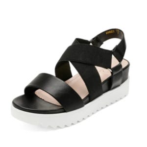 Black sandal with crisscross straps and a white, ridged platform sole.