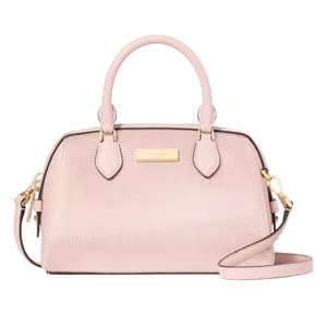 A pink dome-shaped handbag with a textured finish, dual top handles, and a detachable shoulder strap, featuring gold-tone hardware and a logo plaque on the front.