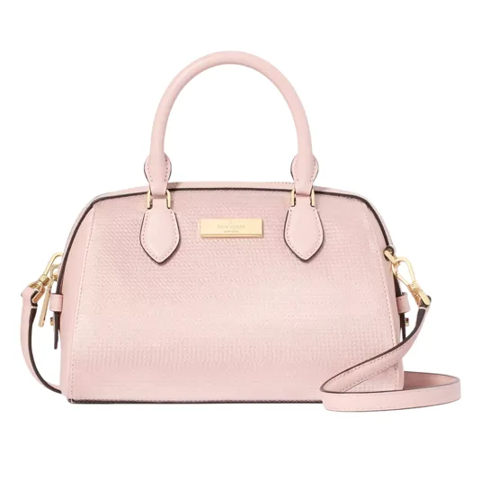 A pink dome-shaped handbag with a textured finish, dual top handles, and a detachable shoulder strap, featuring gold-tone hardware and a logo plaque on the front.