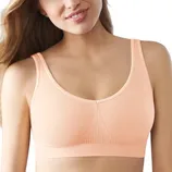 A peach-colored seamless bra with ribbed detailing under the bust and adjustable straps.