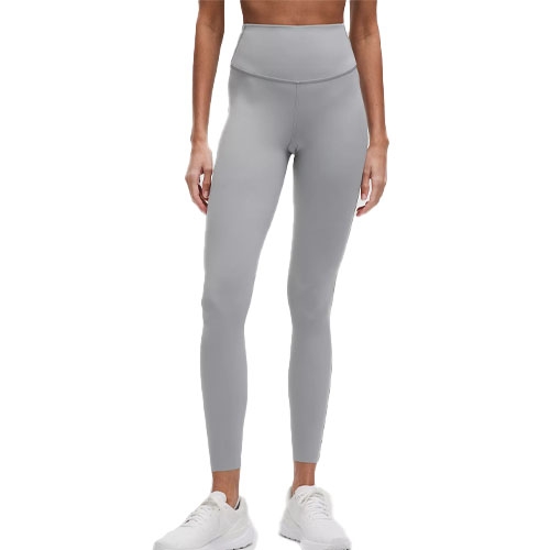 A person is wearing high-waisted, light gray athletic leggings paired with white sneakers.