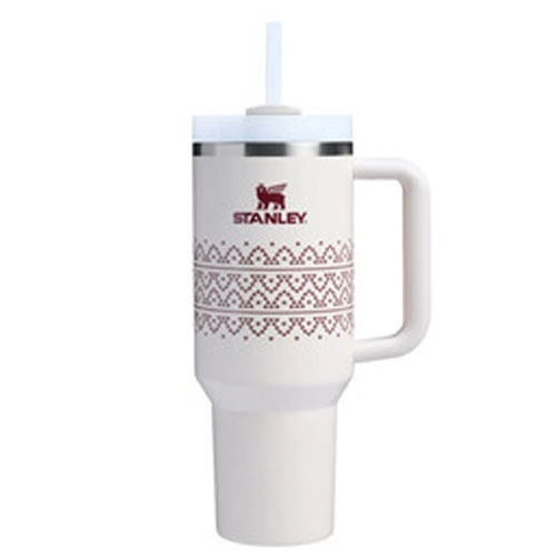 A white Stanley tumbler with a straw, featuring a handle and decorative patterns.
