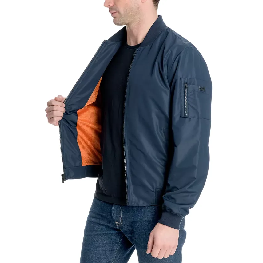 A man is wearing a navy blue bomber jacket with an orange lining, featuring a zippered pocket on the sleeve.