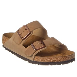 Birkenstock Arizona Leather Sandals feature two adjustable brown straps with copper buckles and a contoured cork footbed for support, set on a dark rubber outsole.