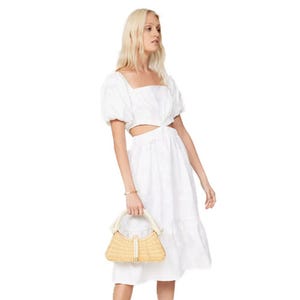 A white midi dress with puffed short sleeves, a square neckline, and side cut-outs, paired with a woven handbag.