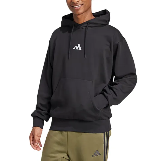 Man wearing a black hoodie with a small logo on the front, paired with olive green sweatpants featuring a similar logo.