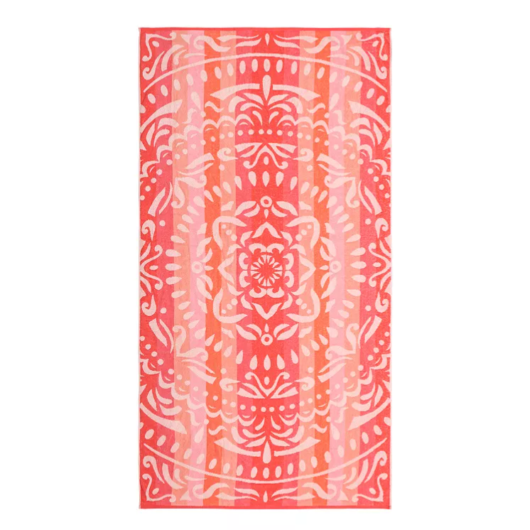 A pink and orange patterned towel featuring a symmetrical, ornate design with floral and abstract elements.