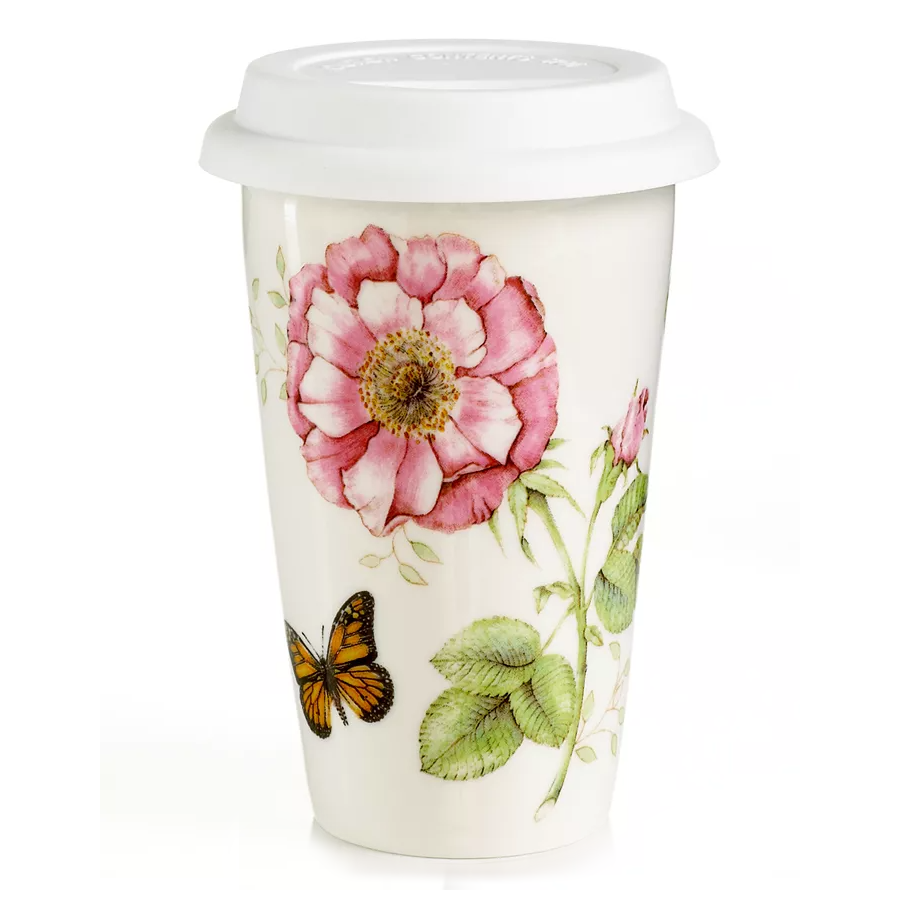 A ceramic travel mug with a white silicone lid, featuring illustrations of a pink flower, green leaves, and an orange butterfly.