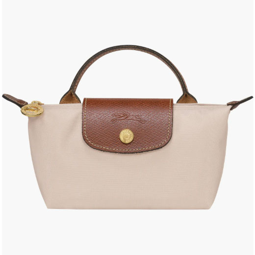 A small beige handbag with a brown leather flap, gold button closure, and a handle.