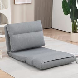 A gray floor sofa flip chair with a cushioned, adjustable backrest is shown in a room with wooden flooring and a rug. It is designed for versatile seating or lounging, featuring three cushioned segments that fold flat or upright.