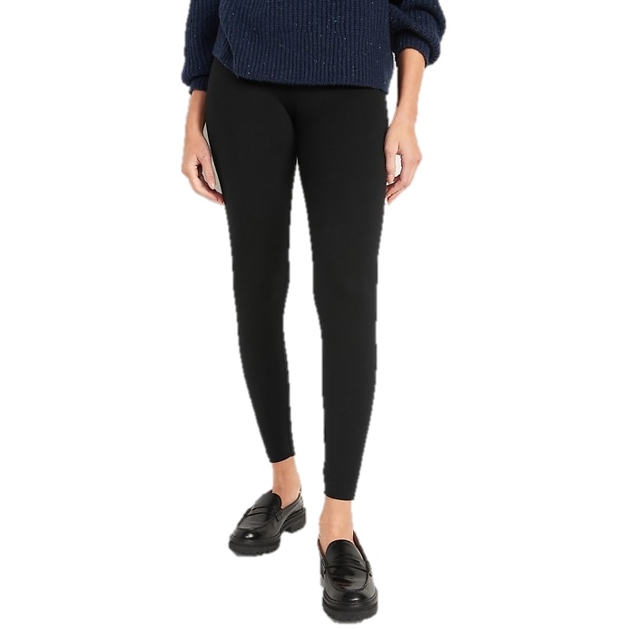 A person is wearing black leggings, black loafers, and a navy blue sweater.