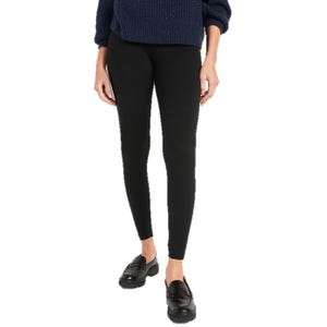 A person is wearing black leggings, black loafers, and a navy blue sweater.
