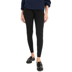 A person is wearing black leggings, black loafers, and a navy blue sweater.