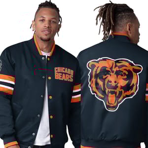 A man is wearing a satin Chicago Bears varsity jacket in black with the team's name on the front and a large bear logo on the back.