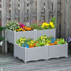 Two-tier grey wicker-style raised garden bed with a variety of colorful flowers against a wooden fence.