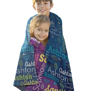 Two children are wrapped in personalized blankets featuring the names \“Ashton\“ and \“Sophia\“ with colorful designs, including pineapples and popsicles.