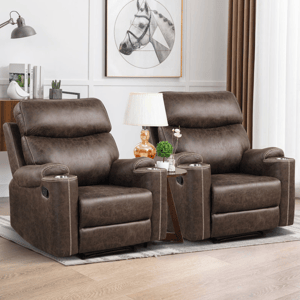 Two brown vegan-leather recliners with high backs and nailhead trim, featuring integrated cup holders and manual recline levers, set on a light wood floor beside a triangular side table with a lamp.