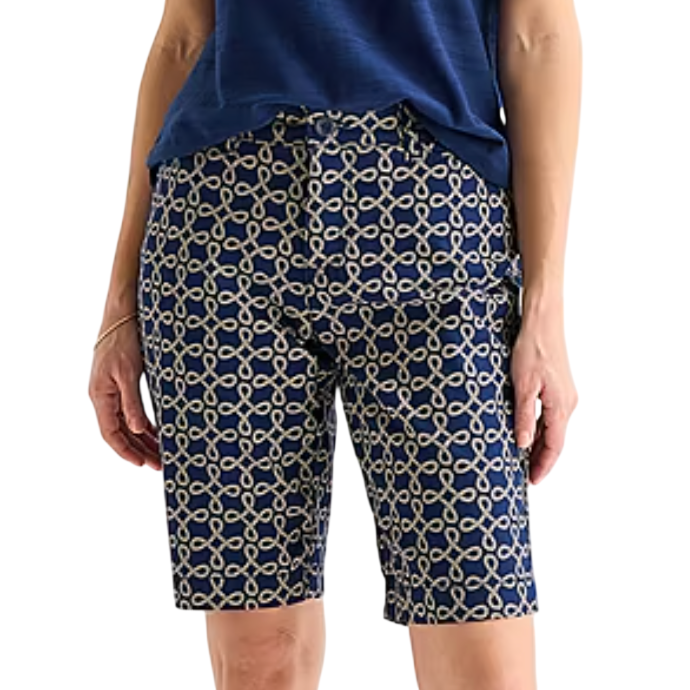 A person wearing blue shorts with a beige chain-link pattern, paired with a tucked-in blue shirt.