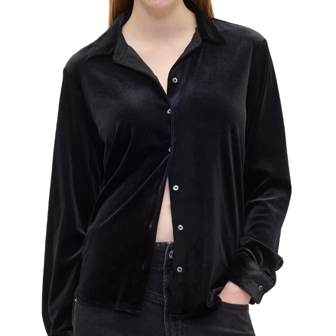 Black long-sleeve velvet button-up shirt with a collar, partially unbuttoned, paired with dark jeans.