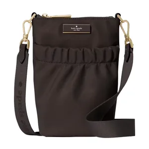 A brown Kate Spade New York crossbody bag with a gold-tone zipper, detachable strap, and front pocket detailing.