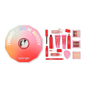 The Ulta Advent Calendar, titled \“Twelve Days of Beauty,\“ contains a variety of cosmetic items such as lip gloss, mascara, eyeshadows, and facial products, presented in a circular pink and red package.
