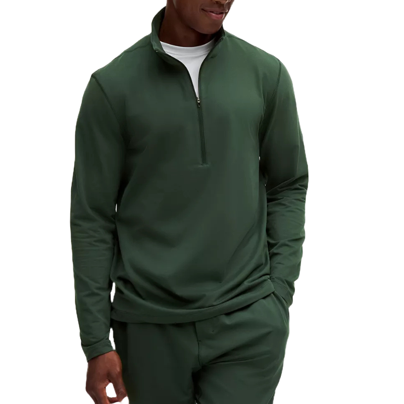 A dark green soft jersey half-zip jacket featuring long sleeves and a relaxed fit, paired with matching pants and layered over a white shirt.