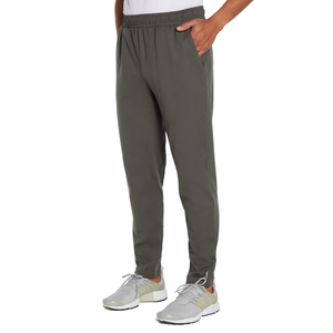 A person is wearing gray jogger pants with an elastic waistband and side pockets, paired with gray and white sneakers.