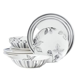 Stacked ceramic dinnerware set with black floral and stripe designs on white background, including bowls and plates.