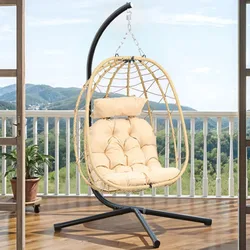 A hanging egg chair with a beige cushion is set on a balcony, featuring a metal stand and a woven basket design.