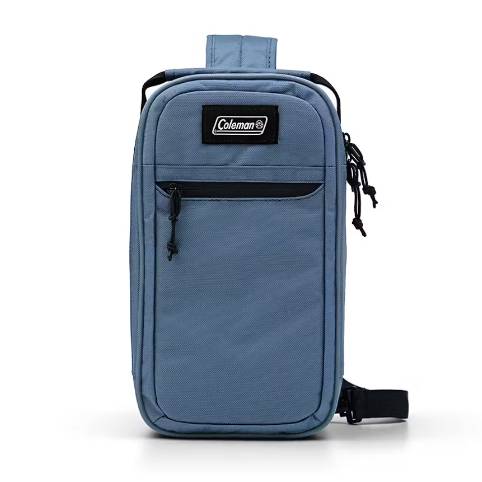 Blue Coleman shoulder bag with a vertical design, featuring a front zippered pocket and adjustable shoulder strap.
