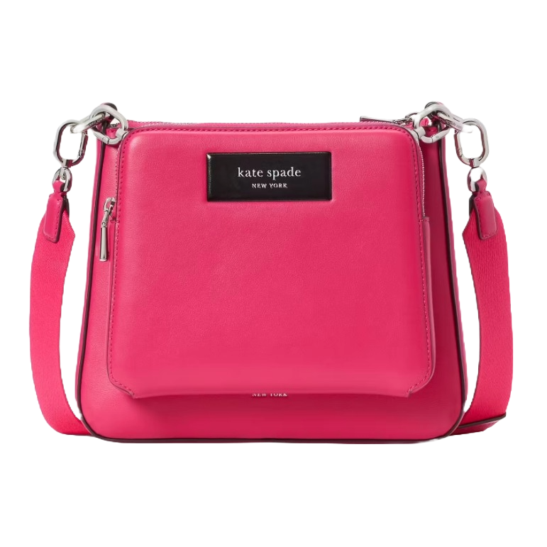 A pink Kate Spade New York crossbody bag with a black logo plate, silver hardware, and an adjustable strap.