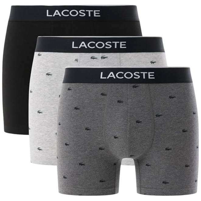 Three pairs of Lacoste boxer briefs in black, light grey, and dark grey with the brand logo on the waistband and small logos on the fabric.