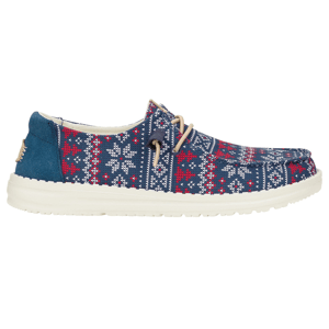 Hey Dude Fairisle Sweater Slip-Ons feature a blue, red, and white patterned fabric with snowflake motifs, cream-colored soles, and beige laces, offering a cozy, winter-themed design.