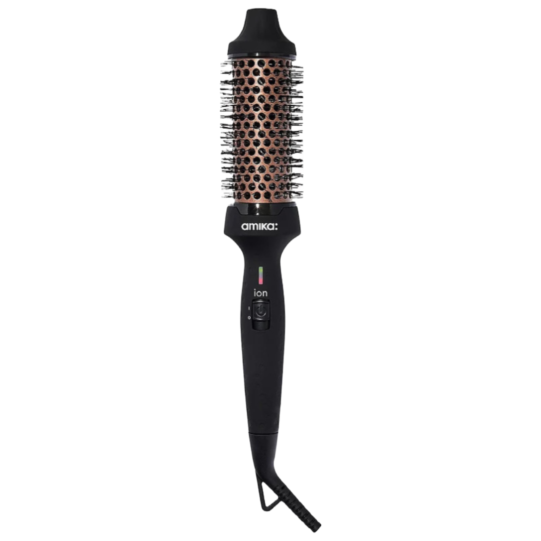 The Amika Blowout Round Brush Dryer features a black handle with an ion switch and an orange ceramic barrel with nylon bristles, designed to dry and style hair simultaneously.