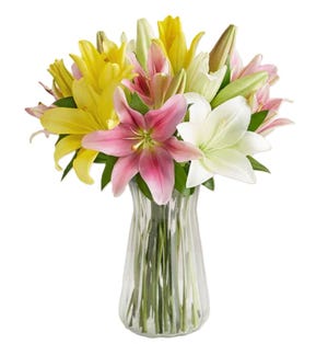 A vibrant bouquet featuring lilies in shades of pink, yellow, and white, arranged in a clear glass vase.
